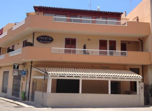 Un edificio con un balcón en el lateral. en B&B Persi Nel Sud, Pozzallo, en Pozzallo