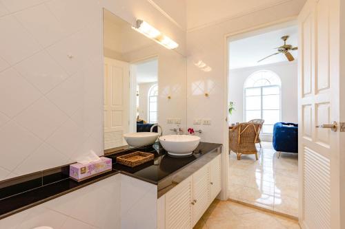 a white bathroom with two sinks on a counter at The White House, Palm Hills Golf and Country Club in Ban Nong Sai