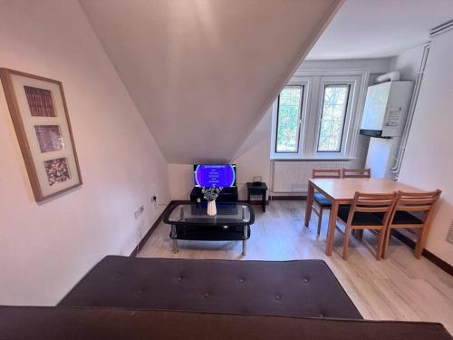 a living room with a table and a tv at Flat 8 near Westfield Centre, 1 Bedroom, 1 Bathroom flat in London