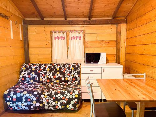 una habitación con sofá y mesa en una cabaña en Le sorgenti - Chalet 57, en Palazzuolo sul Senio