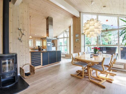eine Küche und ein Esszimmer mit einem Tisch und einem Kamin in der Unterkunft Holiday Home Arlett - 950m from the sea in NW Jutland by Interhome in Fjerritslev