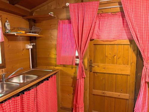 una cocina con fregadero y una puerta en una cabaña en Le sorgenti - Chalet 57, en Palazzuolo sul Senio