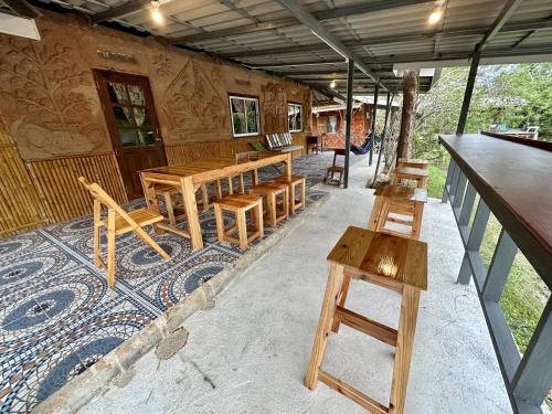 a room with wooden tables and benches in a building at Numpu Baandin in Sam Roi Yot