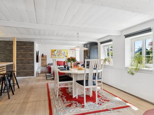 Il comprend une cuisine et une salle à manger avec une table et des chaises blanches. dans l'établissement Holiday Home Alisa - from the sea in NE Jutland by Interhome, à Hadsund