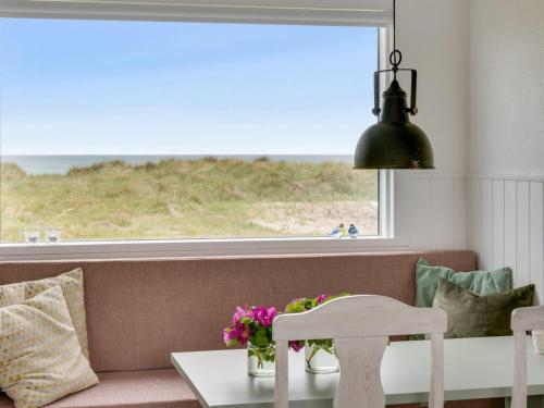 uma sala de estar com um sofá e uma grande janela em Holiday Home Rieke - 40m from the sea in NW Jutland by Interhome em Hjørring