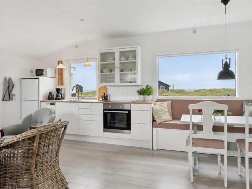 uma cozinha e sala de jantar com mesa e cadeiras em Holiday Home Rieke - 40m from the sea in NW Jutland by Interhome em Hjørring