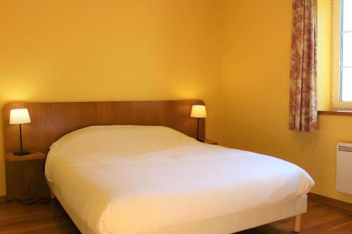 een bed in een slaapkamer met gele muren en 2 lampen bij La Bullote - Gîtes - Paris Roissy in Villeneuve-sous-Dammartin