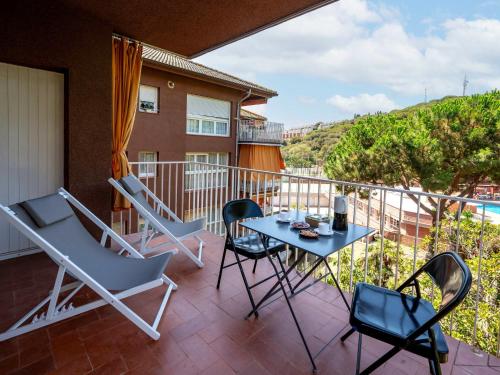 Un patio con sillas y una mesa en el balcón. en Apartment Els Pins by Interhome, en Sant Vicenç de Montalt