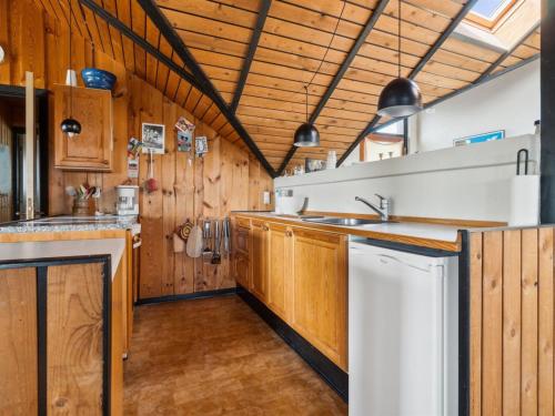 uma cozinha com armários de madeira e um lavatório em Holiday Home Henri - 500m from the sea in NW Jutland by Interhome em Fjerritslev