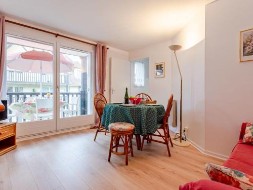 une salle à manger avec une table et des chaises et une fenêtre dans l'établissement Apartment Le Clos Mathilde-21 by Interhome, à Cabourg