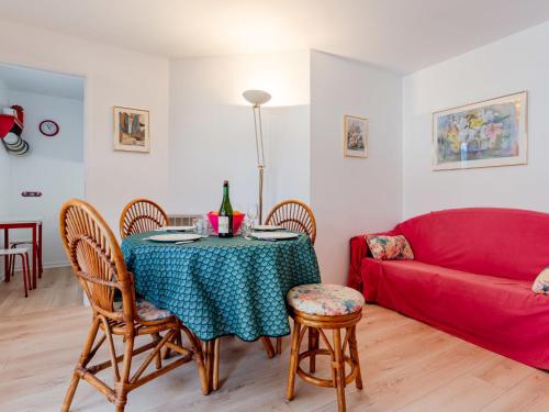un salon avec une table et un canapé rouge dans l'établissement Apartment Le Clos Mathilde-21 by Interhome, à Cabourg