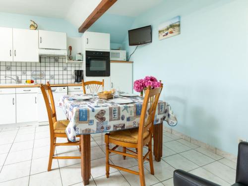 een keuken met een tafel en stoelen met bloemen erop bij Holiday Home opale by Interhome in Saint-Coulomb