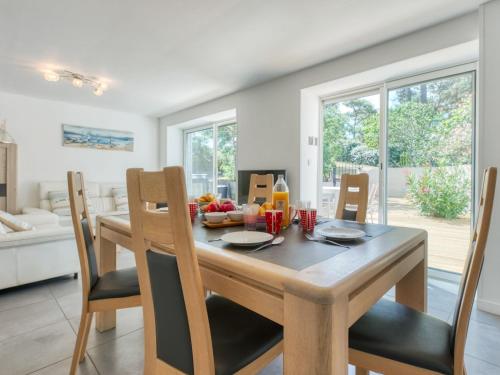 Una cocina y un comedor con mesa y sillas de madera. en Holiday Home Villa Océane by Interhome, en Lacanau-Océan