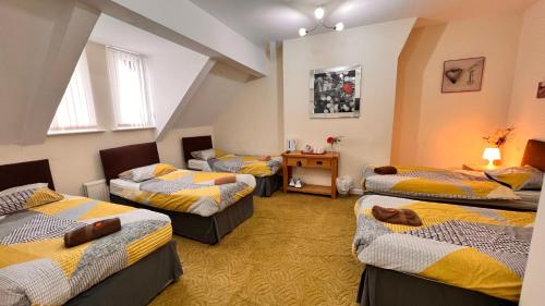 um quarto com quatro camas com amarelo e azul em Castle Lodge Guest House 86-88 Sheil Rd L6 3AF em Liverpool