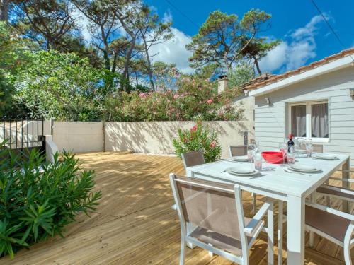 d'une terrasse avec une table et des chaises blanches. dans l'établissement Holiday Home Villa Océane by Interhome, à Lacanau-Océan