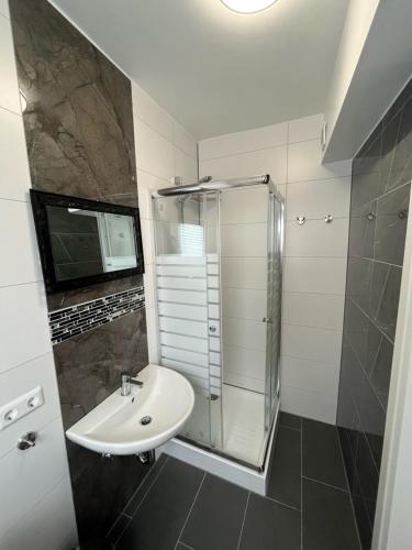 une salle de bain avec un lavabo et une douche dans l'établissement Übernachtung by Tag, à Staufenberg