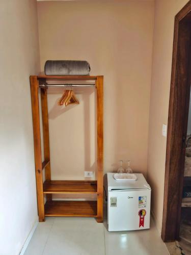 a room with a mirror and a small refrigerator at Pássaros do Cerrado Suítes in Alto Paraíso de Goiás