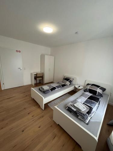 2 camas en una habitación con suelo de madera en Übernachtung by Tag, en Staufenberg