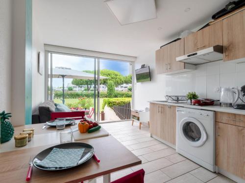 une cuisine avec une machine à laver et une table dans l'établissement Apartment La Lagune-8 by Interhome, au Grau-du-Roi