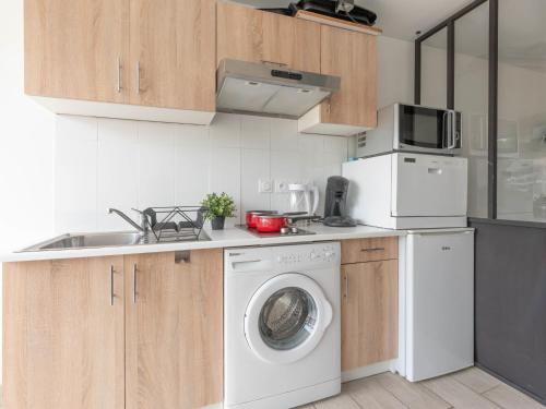 une cuisine avec un lave-linge et un micro-ondes dans l'établissement Apartment La Lagune-8 by Interhome, au Grau-du-Roi