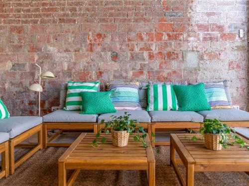 Habitación con sofás, mesas y una pared de ladrillo. en Holiday Home Rita by Interhome, en Malgrat de Mar