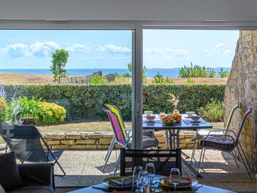 een tafel en stoelen op een patio met uitzicht op de oceaan bij Apartment Les Horizons-2 by Interhome in Carnac