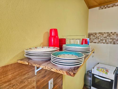 a stack of plates on a shelf in a kitchen at Pássaros do Cerrado Suítes in Alto Paraíso de Goiás