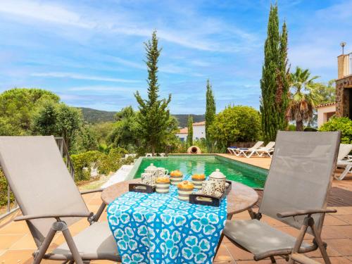 a patio with a table and two chairs and a pool at Holiday Home Can Maggi by Interhome in Calonge