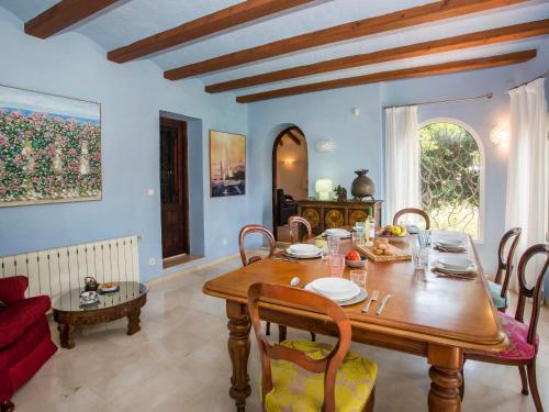 a dining room with a wooden table and chairs at Villa Azul Mediterraneo by Interhome in Jávea