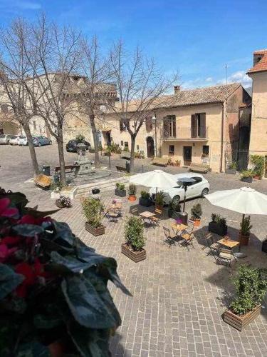 a courtyard with umbrellas and chairs and a building at Libellula Casa Vacanze in Monte Libretti