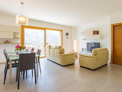 a living room with a table and chairs and a dining room at Apartment Casa Tondi by Interhome in Porlezza