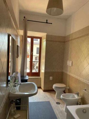 La salle de bains est pourvue de 2 lavabos, de toilettes et d'une fenêtre. dans l'établissement Libellula Casa Vacanze, à Monte Libretti