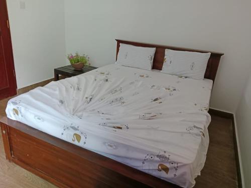 a bedroom with a bed with a white comforter at Home Stay Resort in Nilaveli