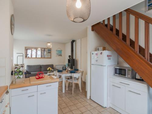 une cuisine avec un réfrigérateur blanc et une table dans l'établissement Holiday Home Les Sylvestres-6 by Interhome, à Cabourg