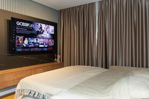 a bedroom with a bed and a flat screen tv at Royalux Kennedy Residences in Tošin Bunar