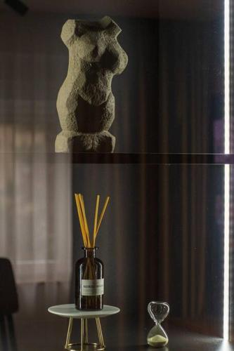a vase with straws in it sitting on a table at Royalux Kennedy Residences in Tošin Bunar