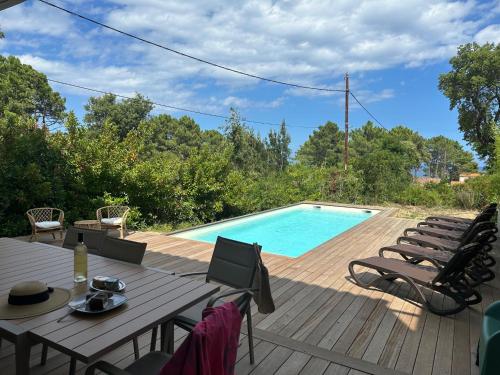 una terraza con mesa y sillas junto a una piscina en Apartment Villa Kalliste by Interhome, en Favone