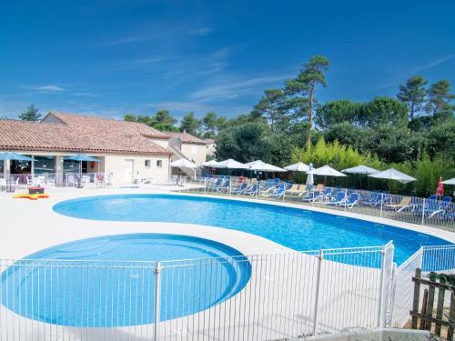 una gran piscina con sillas y sombrillas en Holiday Home Le Jardin du Golf by Interhome en Nans-les-Pins