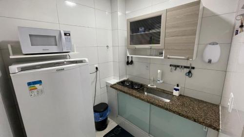 a small kitchen with a sink and a microwave at Apartamento em Santos 100m da praia in Santos