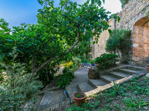 a garden with a tree and a brick building at Apartment Torre 4 by Interhome in Stigliano