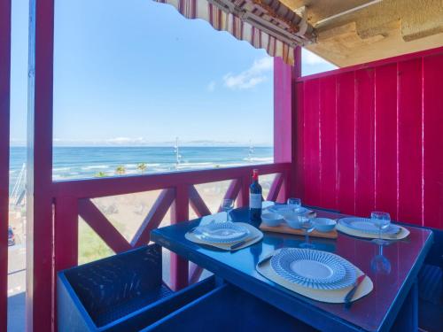 a table with plates and wine glasses on a balcony at Apartment Primavéra-12 by Interhome in Lacanau-Océan