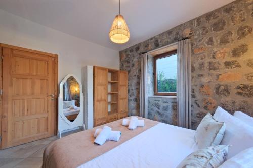 a bedroom with a large bed and a window at VILLAS KAYAKOY 1 OLUDENIZ/FETHIYE in Kayakoy