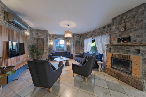 a living room with a stone fireplace and furniture at VILLAS KAYAKOY 1 OLUDENIZ/FETHIYE in Kayakoy