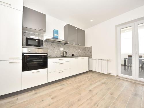 a kitchen with white cabinets and a large window at Apartment Franka by Interhome in Pašman