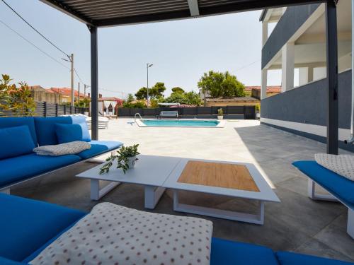 a patio with a white table and chairs and a pool at Apartment Franka by Interhome in Pašman