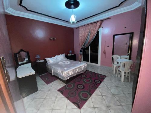 een slaapkamer met een bed en een tafel en stoelen bij إقامة المقاومة قرب سوق الحد اكادير in Agadir