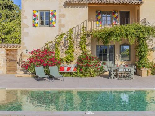 une maison avec une table et des chaises à côté d'une piscine dans l'établissement Holiday Home Le Mas de Marius by Interhome, à Cavaillon