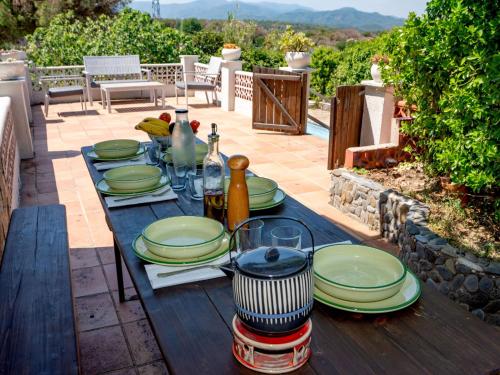 una mesa de madera con platos y platos. en Holiday Home Mas Altaba by Interhome, en Maçanet de la Selva