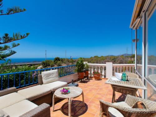 eine Terrasse mit einem Sofa und Stühlen auf dem Balkon in der Unterkunft Villa Helene by Interhome in Nerja