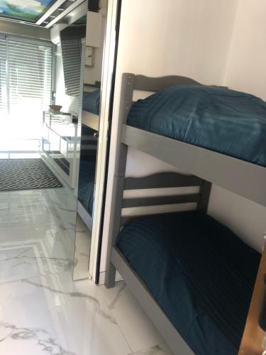 um quarto com 3 beliches e um espelho em 24 Appart Tropic Deluxe em Cap d'Agde
